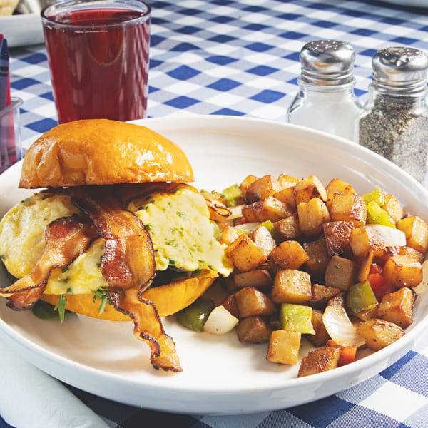 The Breakfast Boys' brunch plate with a bacon, egg, and cheese sandwich and home fries.